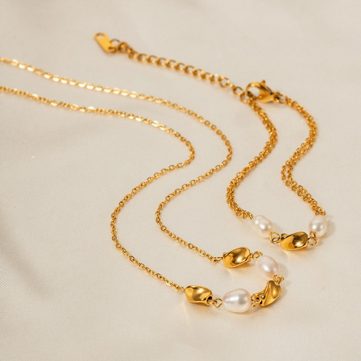 Parure Perla — bracelet et collier dorés à perles sur satin ivoire