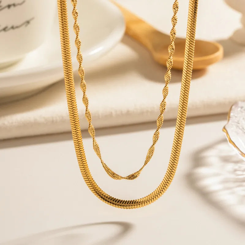 Détail des deux chaînes dorées : maille plate et maille torsadée